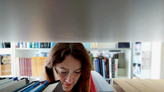 Direktora vietniece Anita Fišere bibliotekā lasa grāmatu.