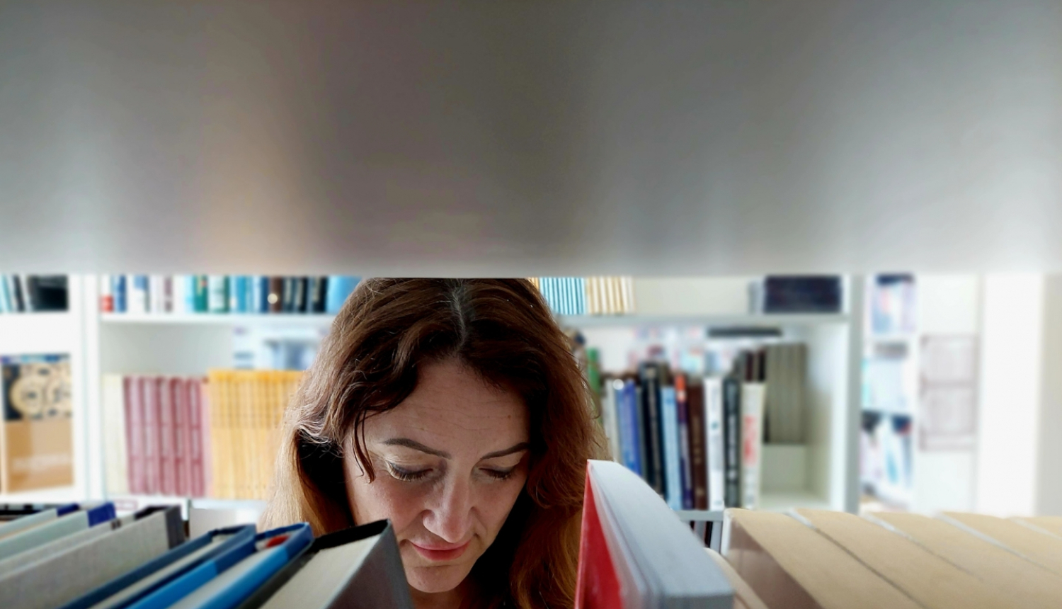 Direktora vietniece Anita Fišere bibliotekā lasa grāmatu.