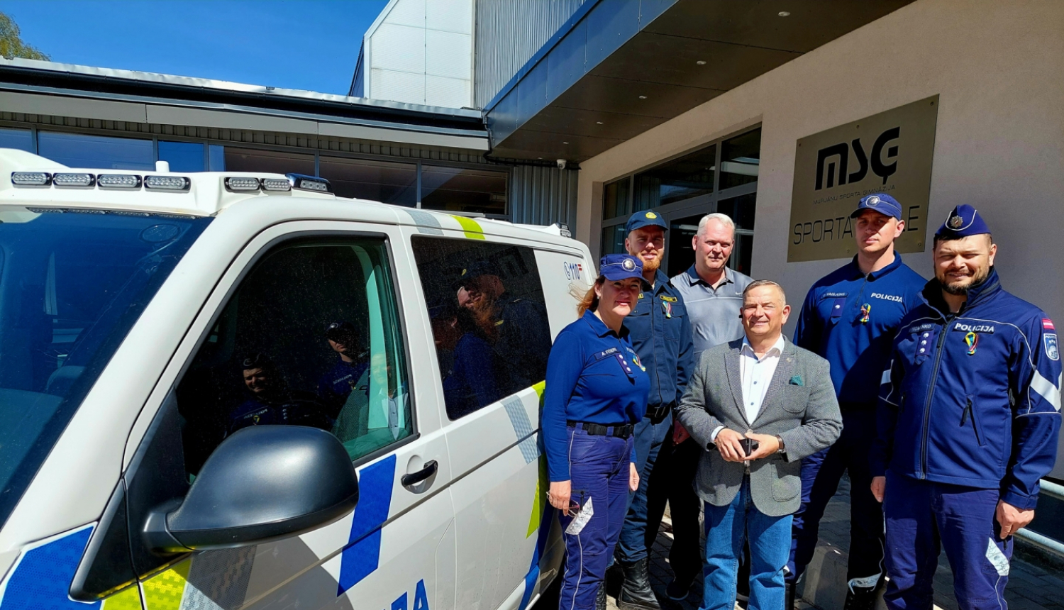 Valsts policijas koledžas un Murjāņu sporta ģimnāzijas pārstāvju kopbilde pie Valsts policijas dienesta transportlīdzekļa